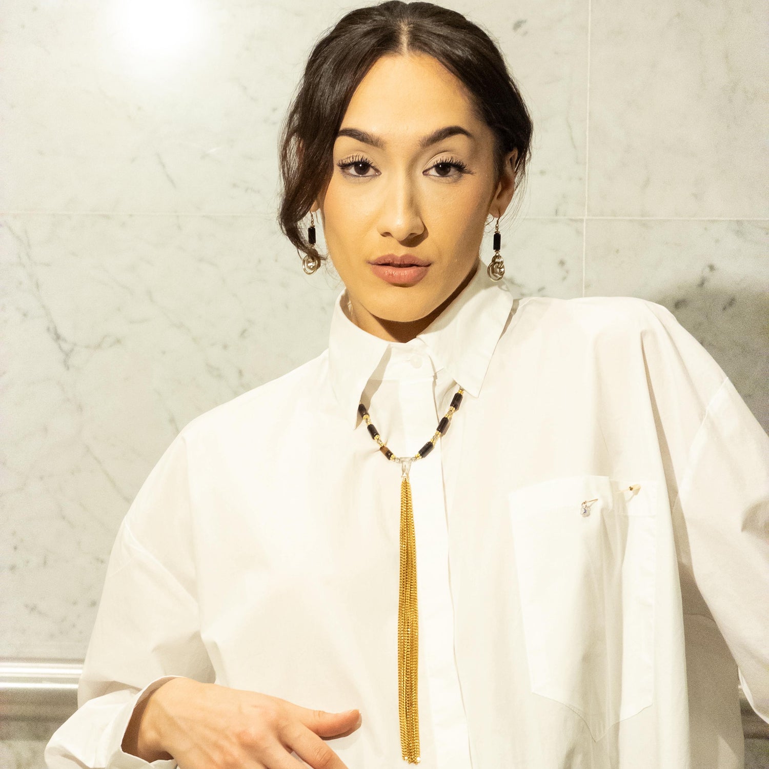 A woman wearing MONOXIDE jewellery with an architectural white shirt